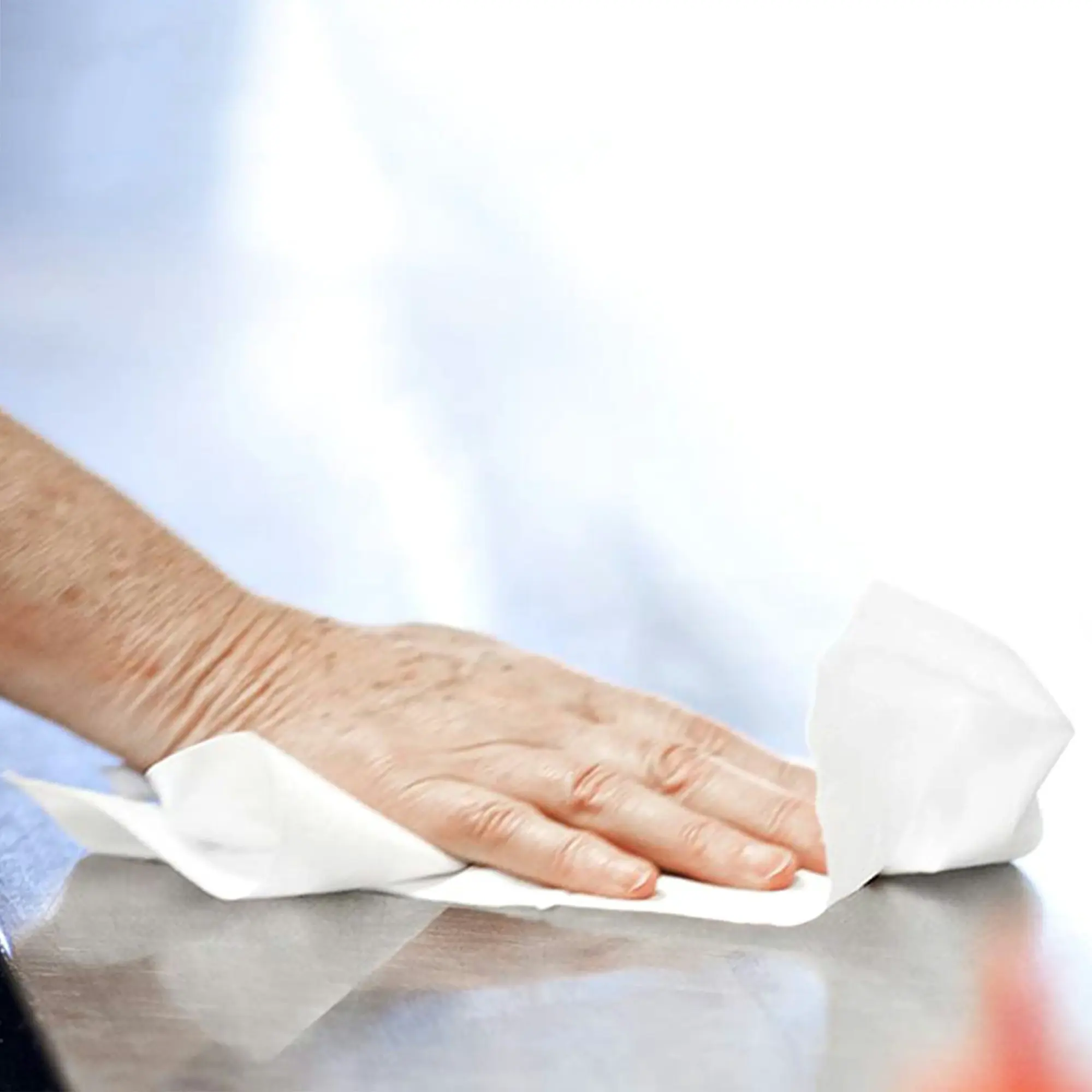 Tork czyściwo papierowe do średnich zabrudzeń, dłoń czyszcząca gładką powierzchnię białym arkuszem papieru