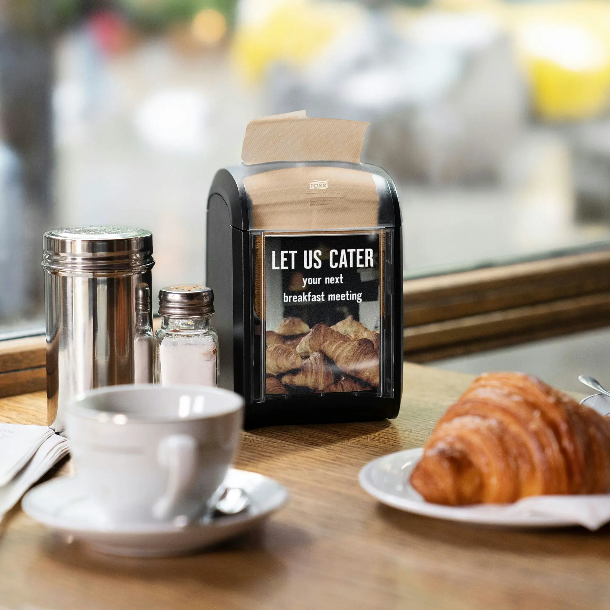 Tork Xpressnap Fit naturalne serwetki dyspenserowe N14, czarny dozownik nablatowy z reklamą Let Us Cater